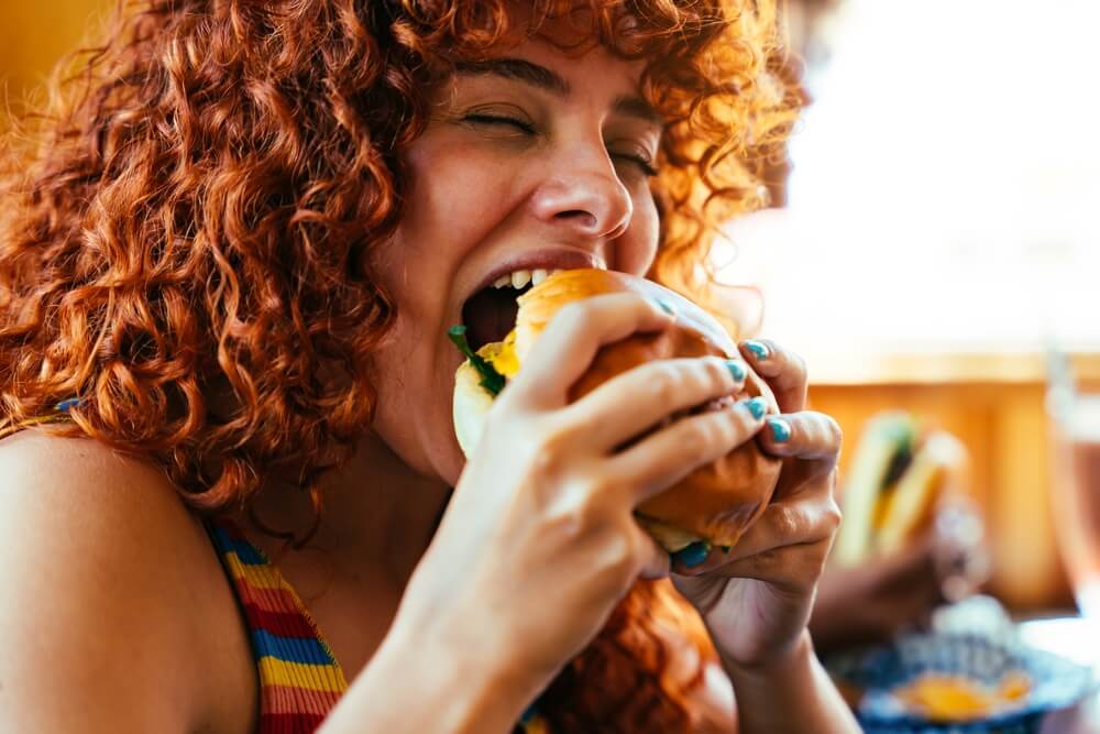 Turtle Bay Restaurants and Food Trucks Locals Recommend: A woman enjoying a sandwich